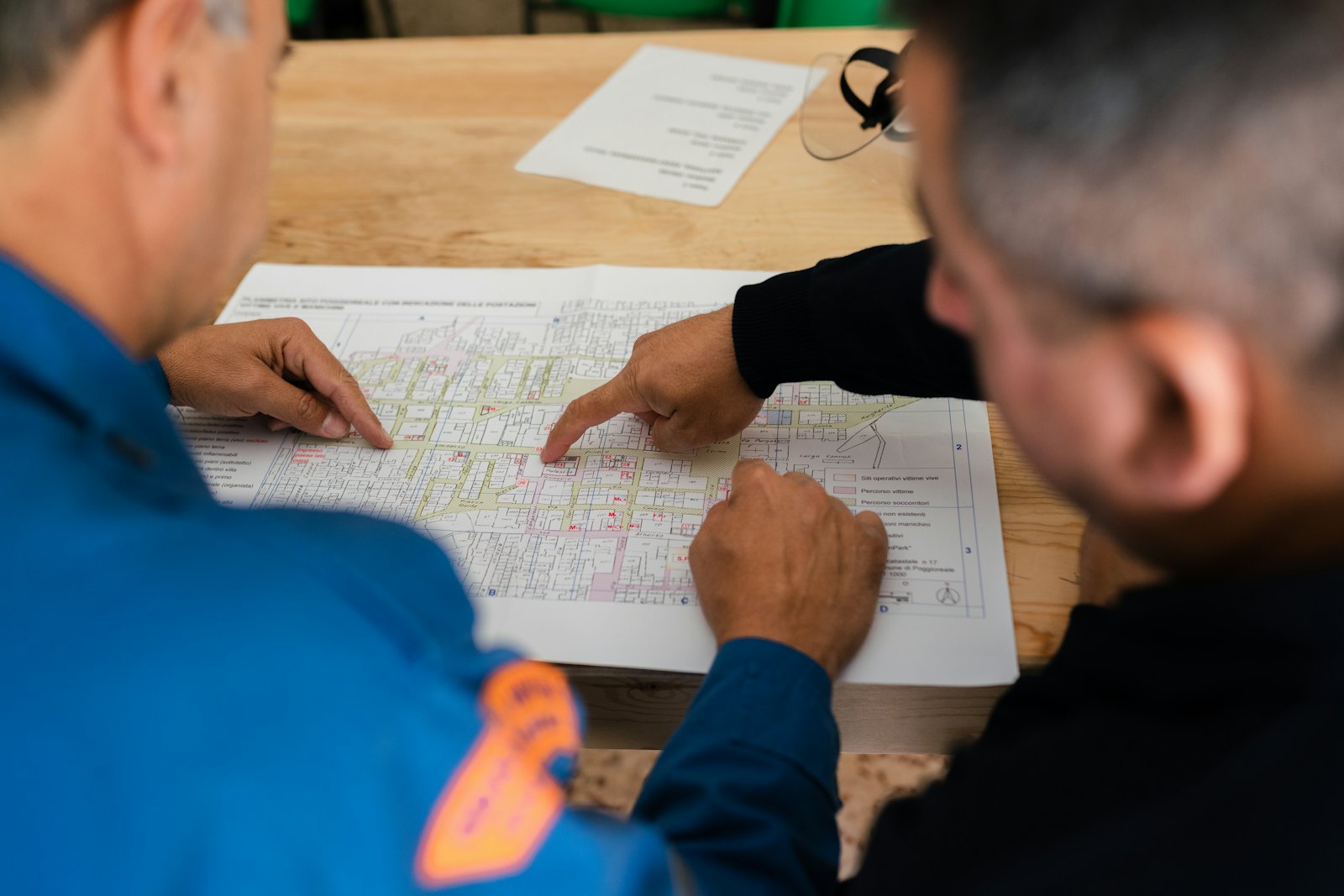 Dos ingenieros revisando planos impresos sobre una mesa